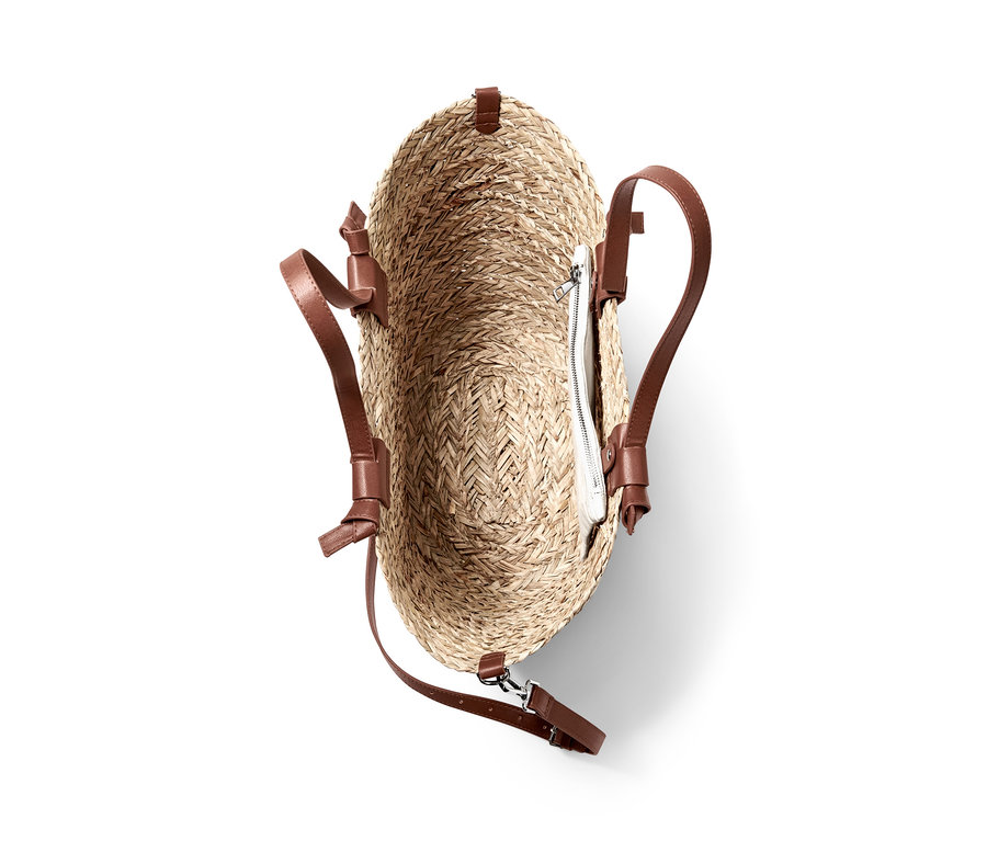 Detailaufnahme einer Korbtasche mit braunen Ledergriffen und einer herausnehmbaren Reißverschlusstasche im Inneren.