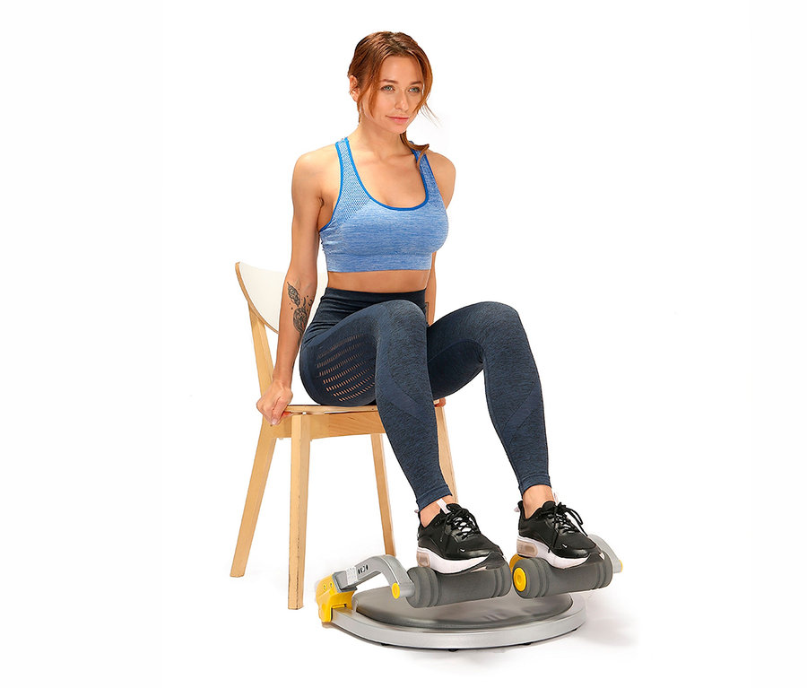 Frau sitzt auf einem Stuhl und trainiert mit dem Body Coach Fitnessgerät Core Trimmer 28521.