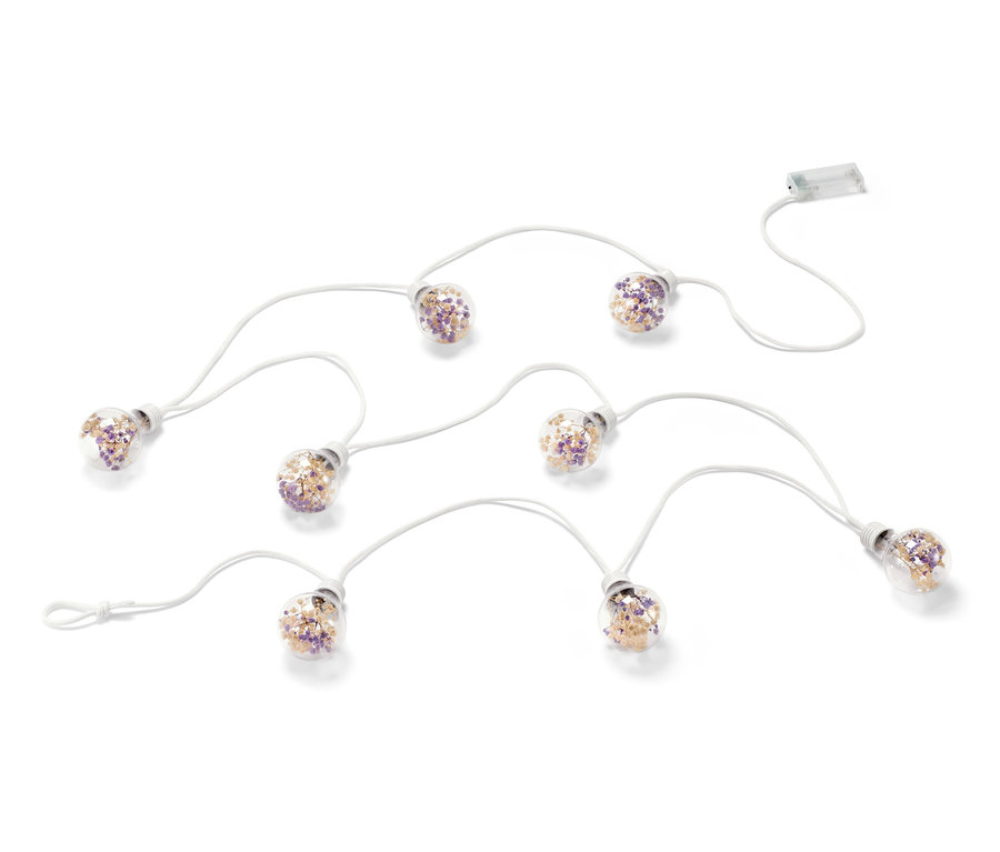 LED-Lichterkette mit Trockenblumen auf weißem Hintergrund.