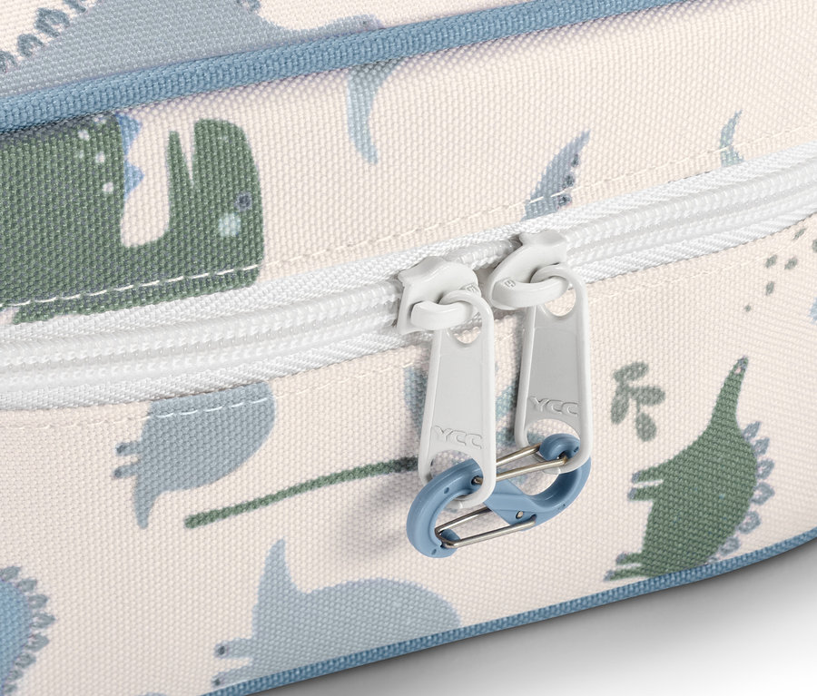 Detail einer Medikamententasche mit Dinosaurier-Muster und weißem Reißverschluss.