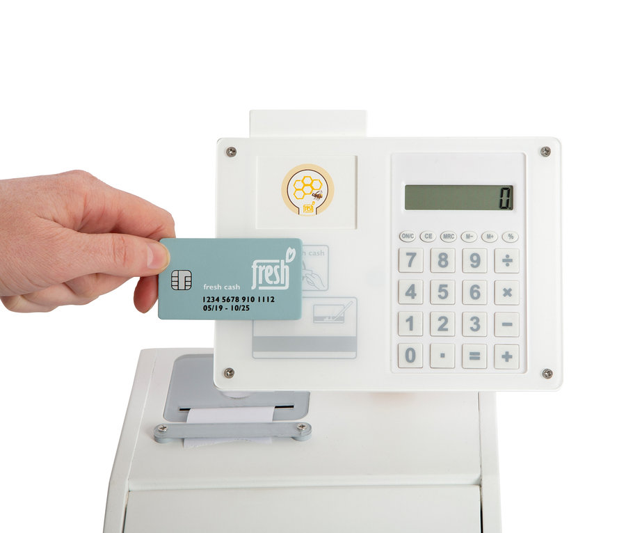 Eine Hand hält eine Fresh Cash Karte an einer Small Foot Kasse "fresh".