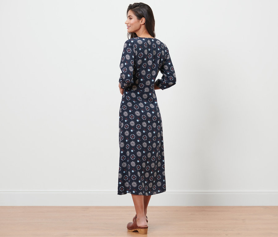 Frau posiert in einem Kleid mit Print.