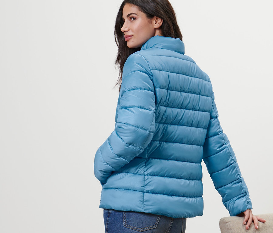 Frau posiert in Steppjacke.