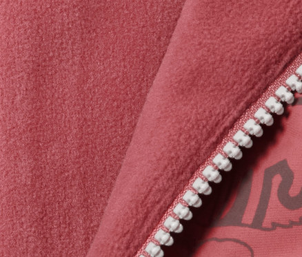 Detail einer Kinder Thermo-Regenhose mit reflektierenden Elementen in Beerefarbe, mit Reißverschluss und Fleecefutter.
