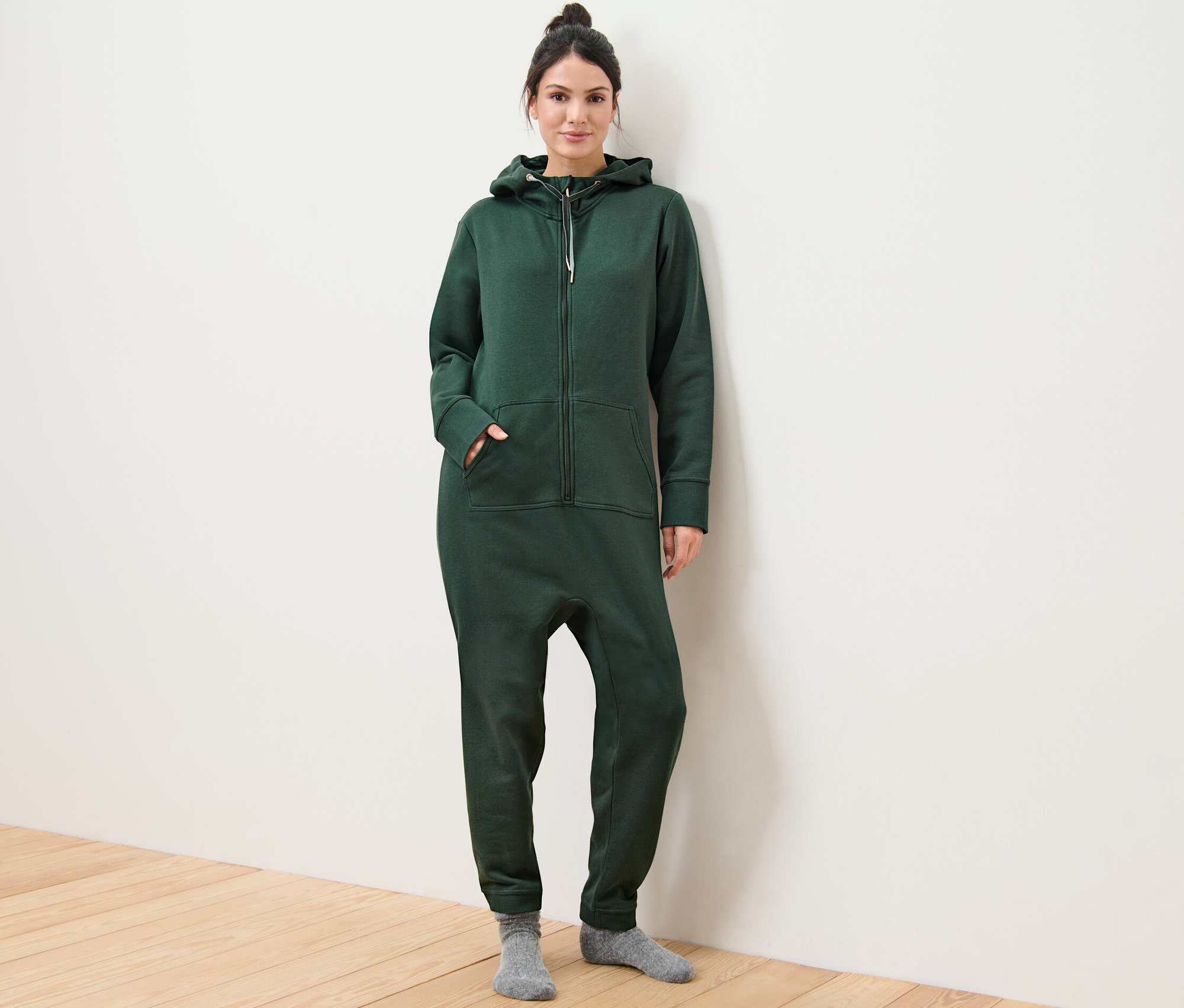 Frau posiert in dunkelgrünem Loungeoverall.