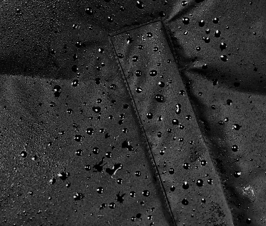 Detailaufnahme eines Winter-Regenmantels mit Wassertropfen.