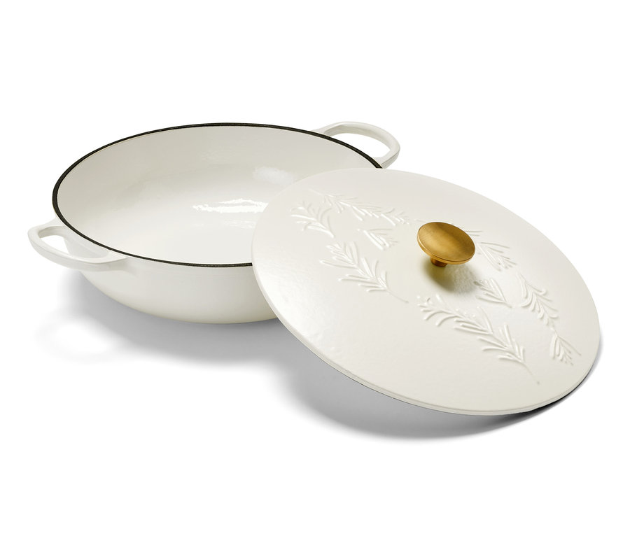 Eine weiße Gusseisen-Servierpfanne mit Deckel und goldenem Griff.