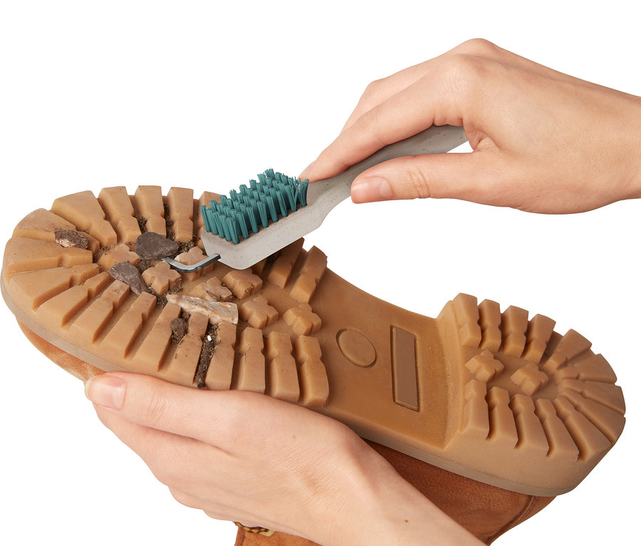 Hände reinigen eine Schuhsohle mit einer Grobschmutz-Schuhsohlenreinigungsbürste.