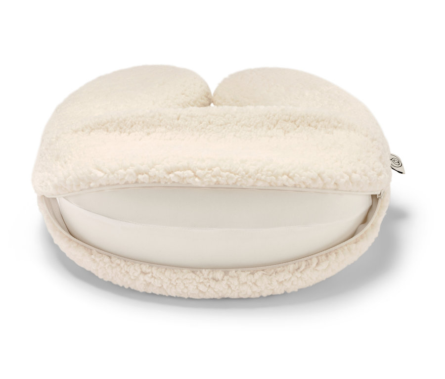 Ein Memory-Foam-Nackenkissen in Creme auf einem weißen Hintergrund.