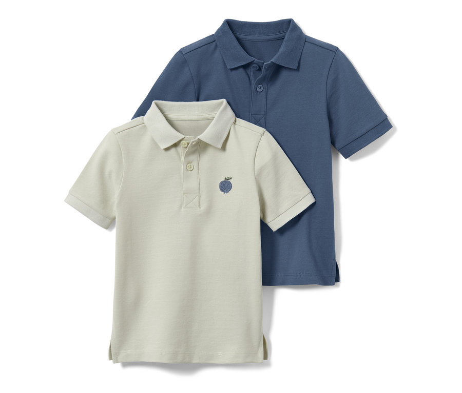 Zwei Kleinkind-Poloshirts, eines hellbeige mit Apfelstickerei, das andere blau.