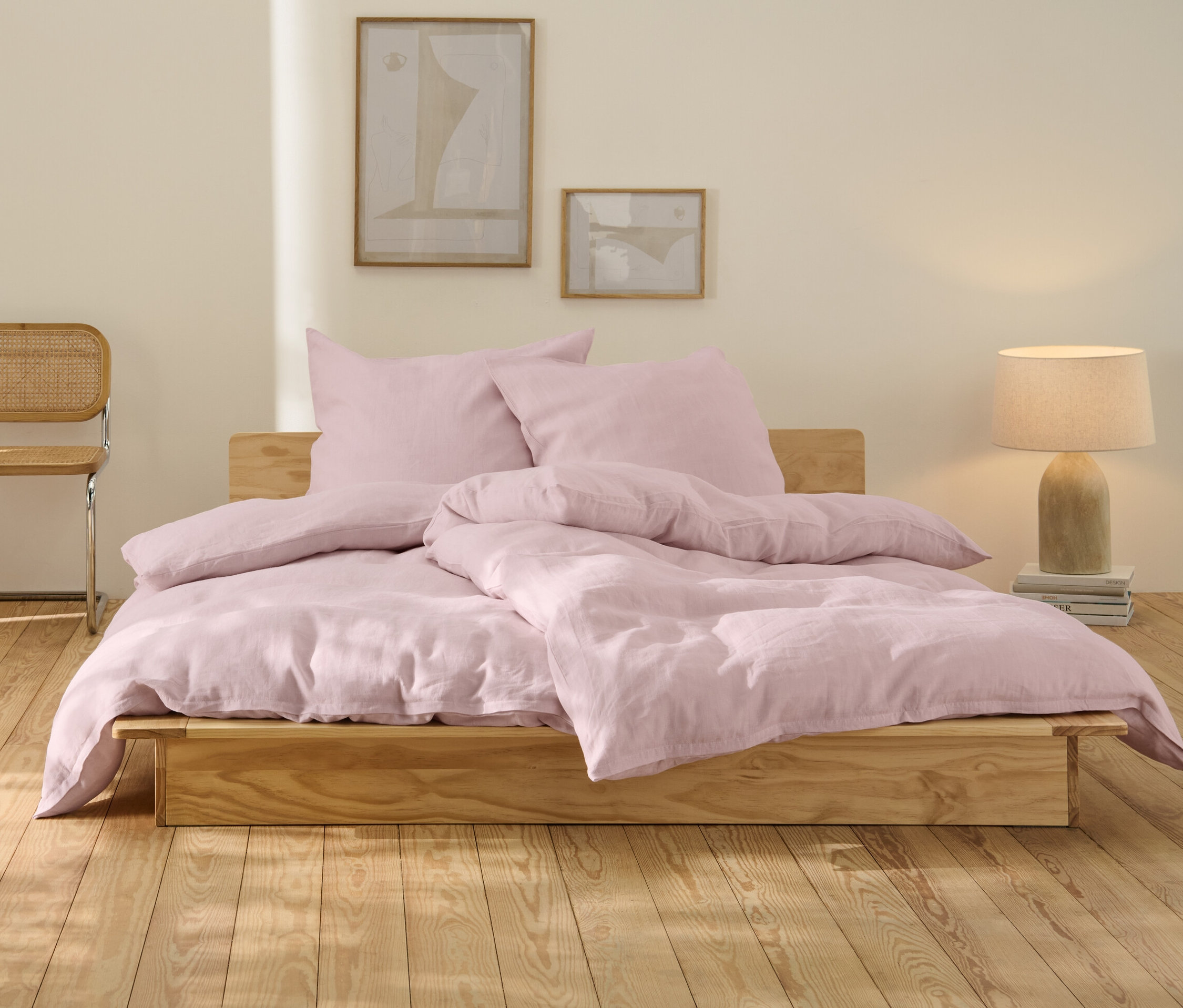 Rosafarbene Leinen-Bettwäsche in Normalgröße und Übergröße auf einem Holzbett.