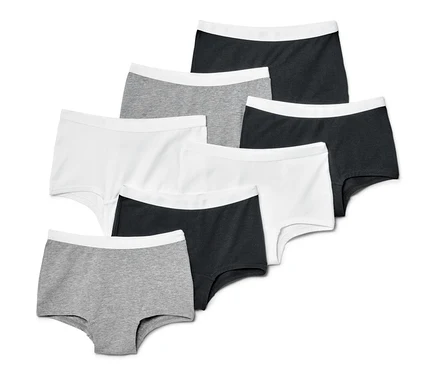 Sieben Kinder-Pantys in Grau, Weiß und Schwarz sind in einer übersichtlichen Komposition angeordnet.