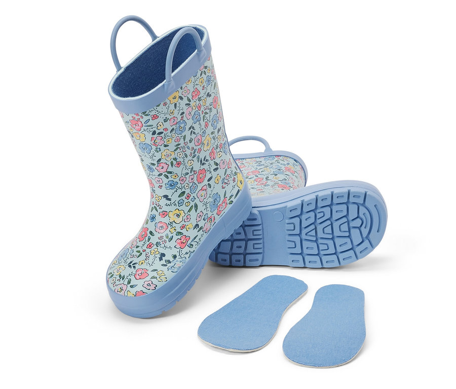 Kinder-Regenstiefel mit Blumenmuster und Schuheinlagen auf weissem Hintergrund.