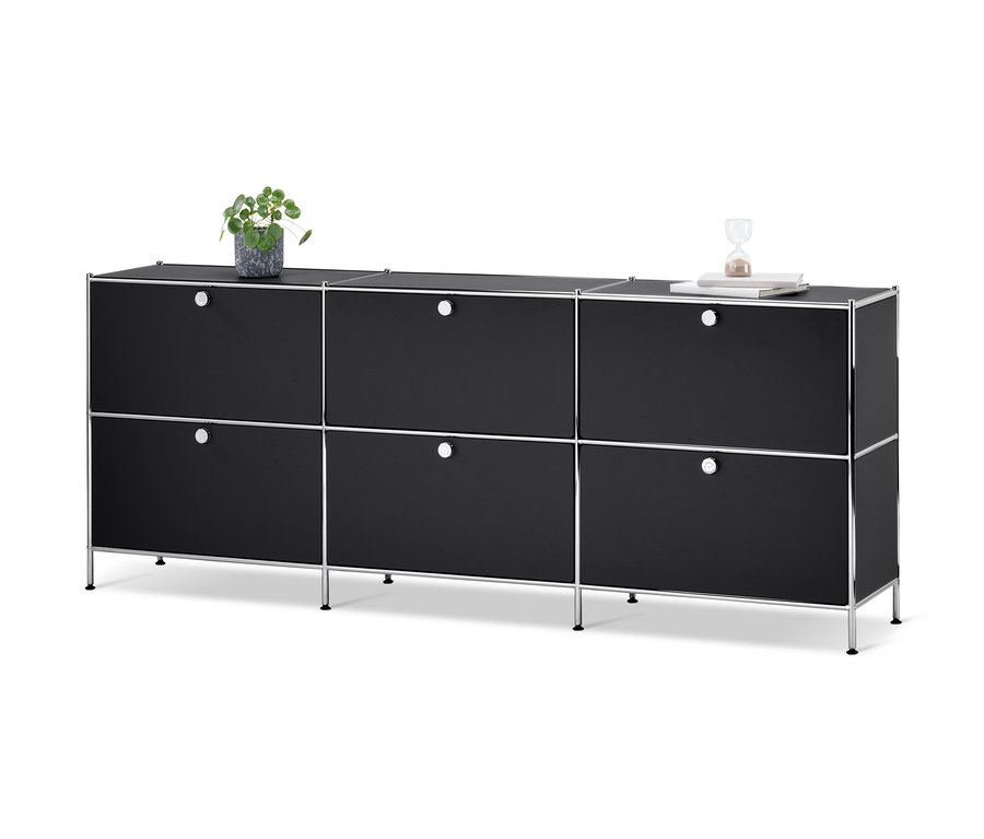 Schwarzes Sideboard »CN3« mit 6 Klappen. Auf der Oberseite befinden sich eine Pflanze und eine Sanduhr.