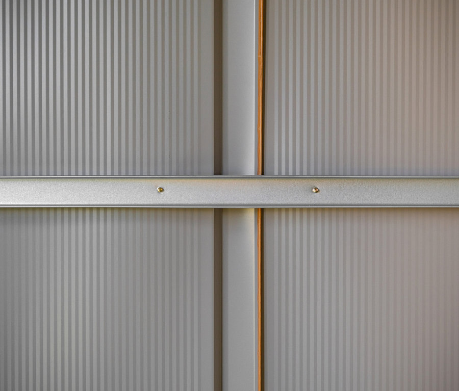 Detailansicht eines grauen Metallgerätehauses.