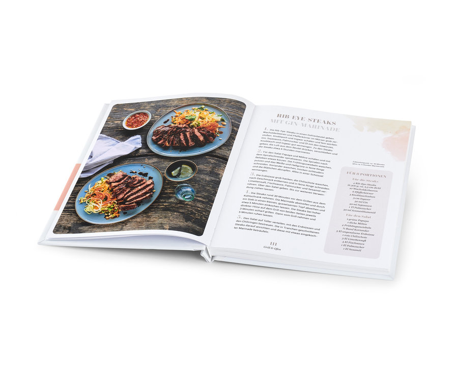 Aufgeschlagenes Kochbuch mit zwei Tellern mit aufgeschnittenem Steak und Salat neben einer Schüssel mit Sauce. Abgebildet ist das Buch »Sommerküche«.