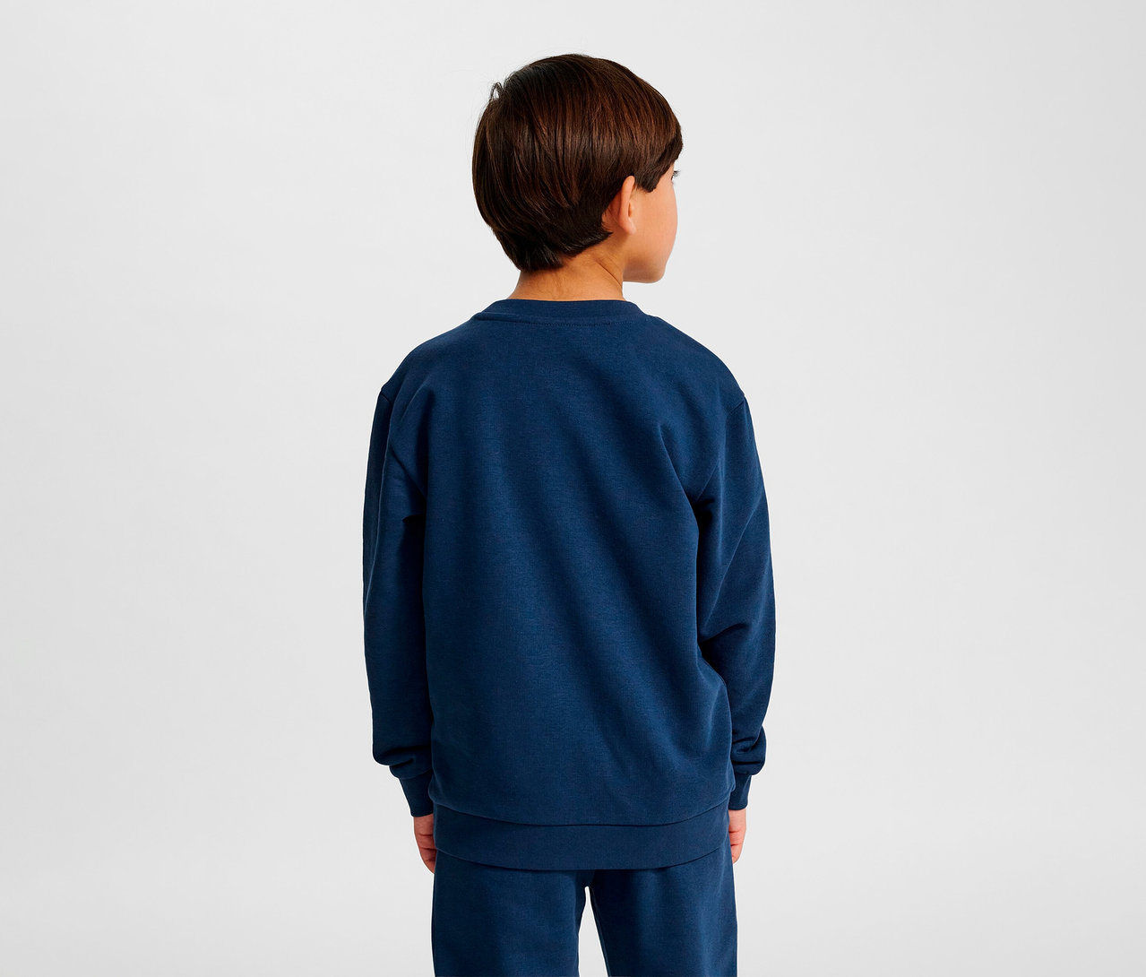 Junge von hinten trägt blaues HUMMEL HMLJR Base-Sweatshirt.