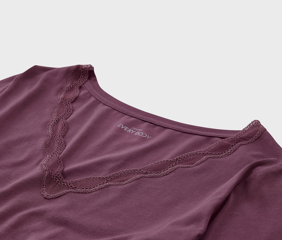 Detailaufnahme eines lilafarbenen T-Shirts mit V-Ausschnitt und Spitzenbesatz.
