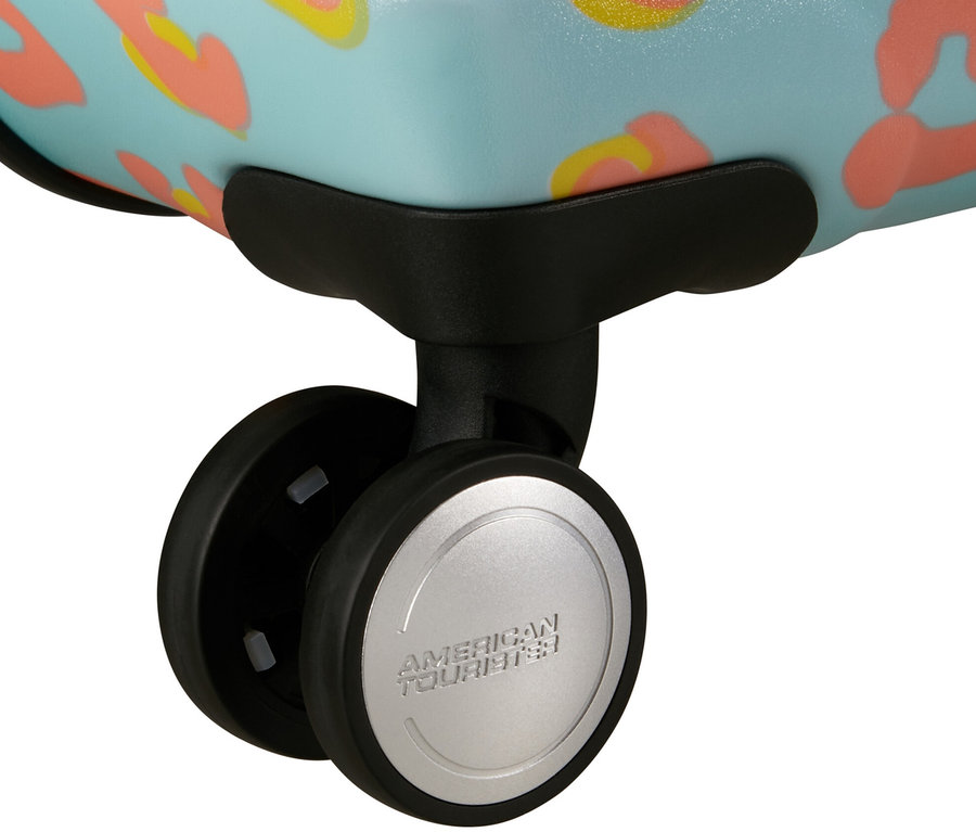 Nahaufnahme der Rollen eines großen American Tourister Wavebreaker »Minnie Mouse« Koffers mit blauem Hintergrund und orangefarbenen Flecken.