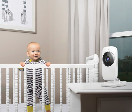 Baby steht im Gitterbett neben dem Video-Babyphone "VM481".