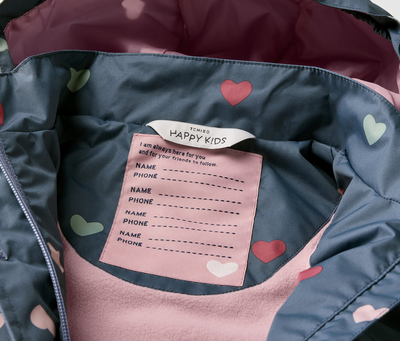 Detailaufnahme einer Kinder-Thermo-Regenjacke mit Herzmuster.