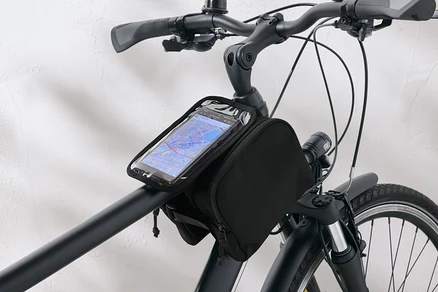 Schwarze Fahrradtasche mit durchsichtiger Handytasche am Lenker eines Fahrrads befestigt.