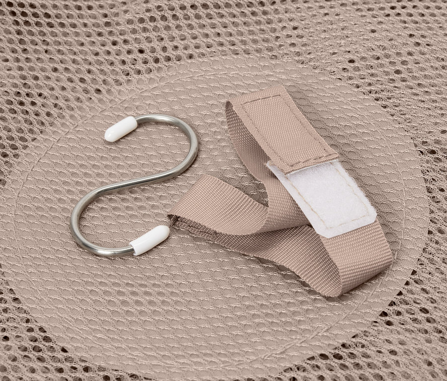 Ein Haken und ein Riemen liegen auf einem beige Aufbewahrungsnetz.