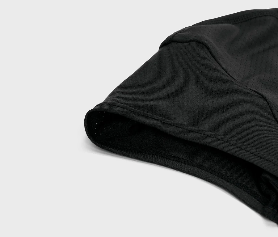Nahaufnahme eines schwarzen Kleidungsstücks mit Mesh-Details und einem gefütterten Saum.