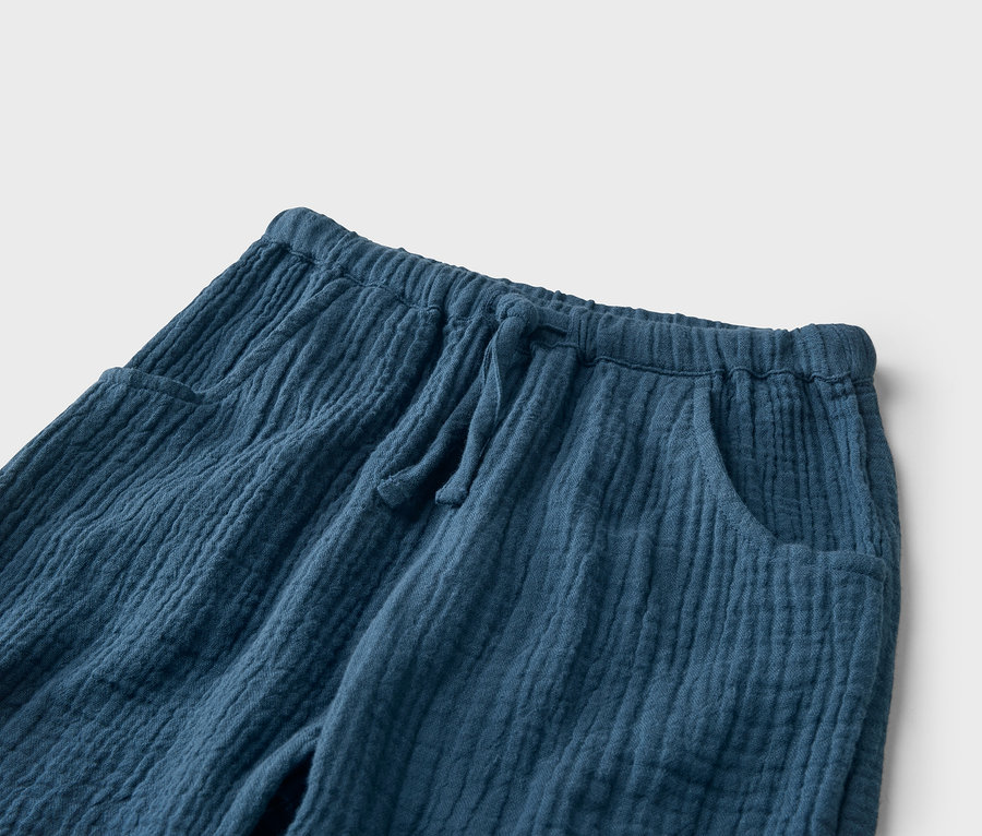 Nahaufnahme einer blauen Hose aus Musselin mit Kordelzug und Taschen.