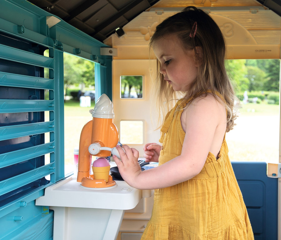 Mädchen spielt im Smoby Life Spielhaus »Sweety Corner« mit einer Spielzeug-Eismaschine.