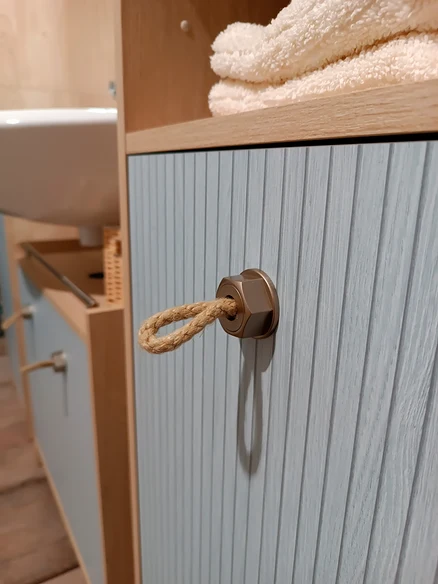 Detailaufnahme vom Badezimmer: Waschtisch »Sonderby« in Nordic Blue Oak mit Seil-Griff, Hochschrank »Sonderby« in Nordic Light Oak und Handtücher.