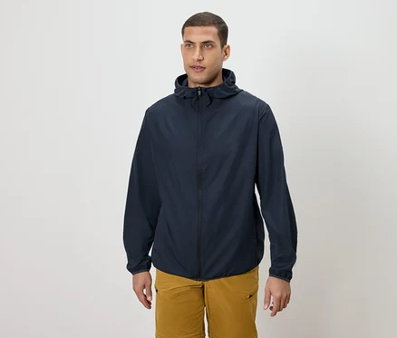 Mann trägt eine marineblaue Kapuzenjacke und goldene Shorts.
