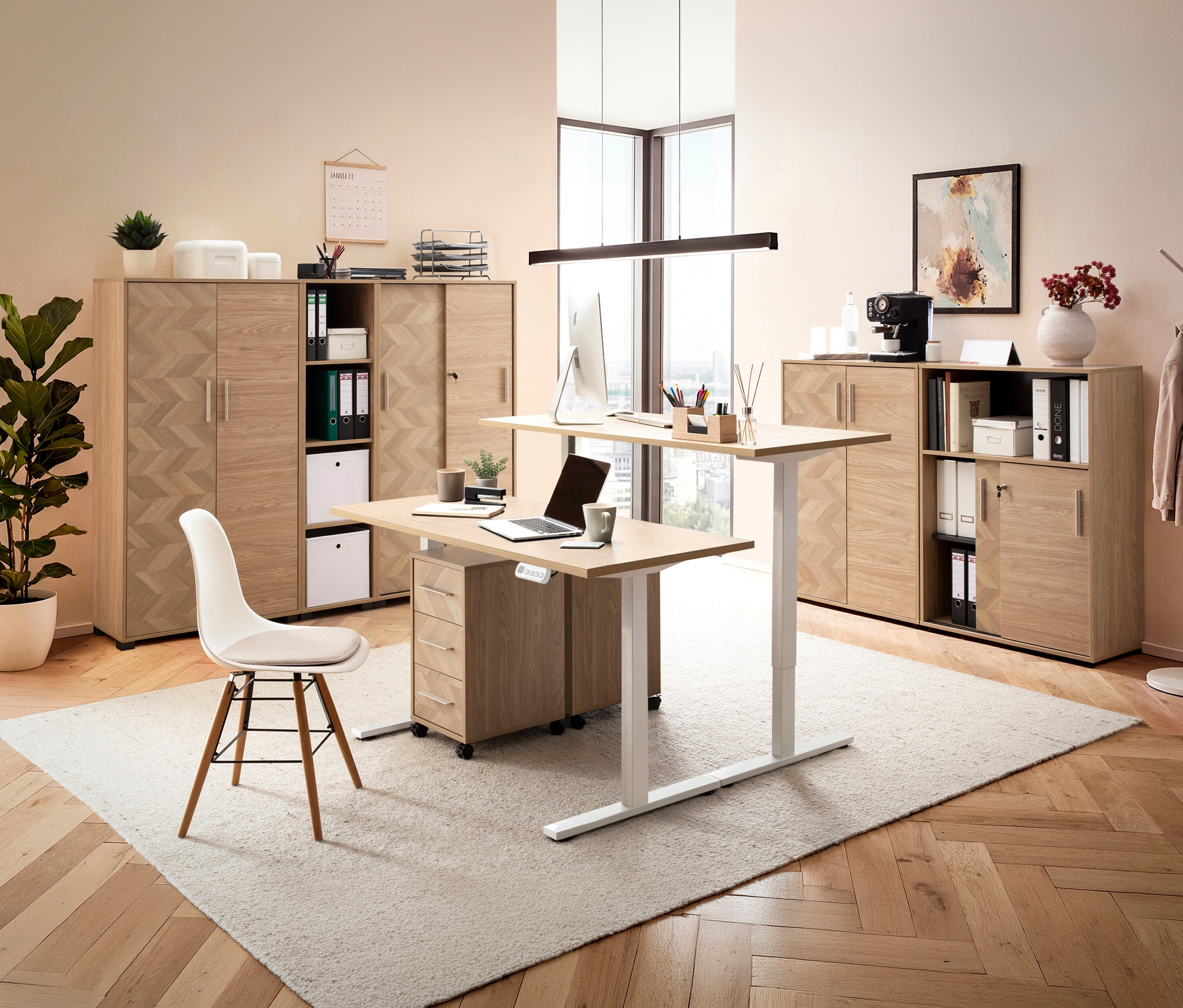 Büro mit höhenverstellbarem Schreibtisch und Rollcontainer »Piazza« in Mauve mit Fischgräten-Dekor unter dem Tisch.