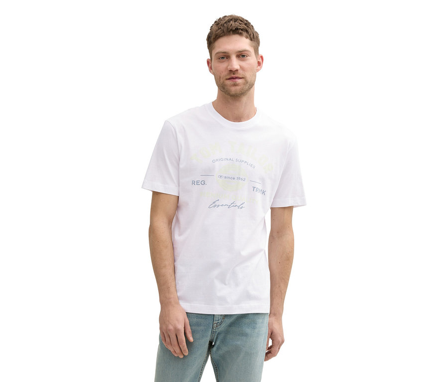 Mann mit hellbraunem Haar trägt ein weißes Tom Tailor T-Shirt mit Logo und helle Jeans.