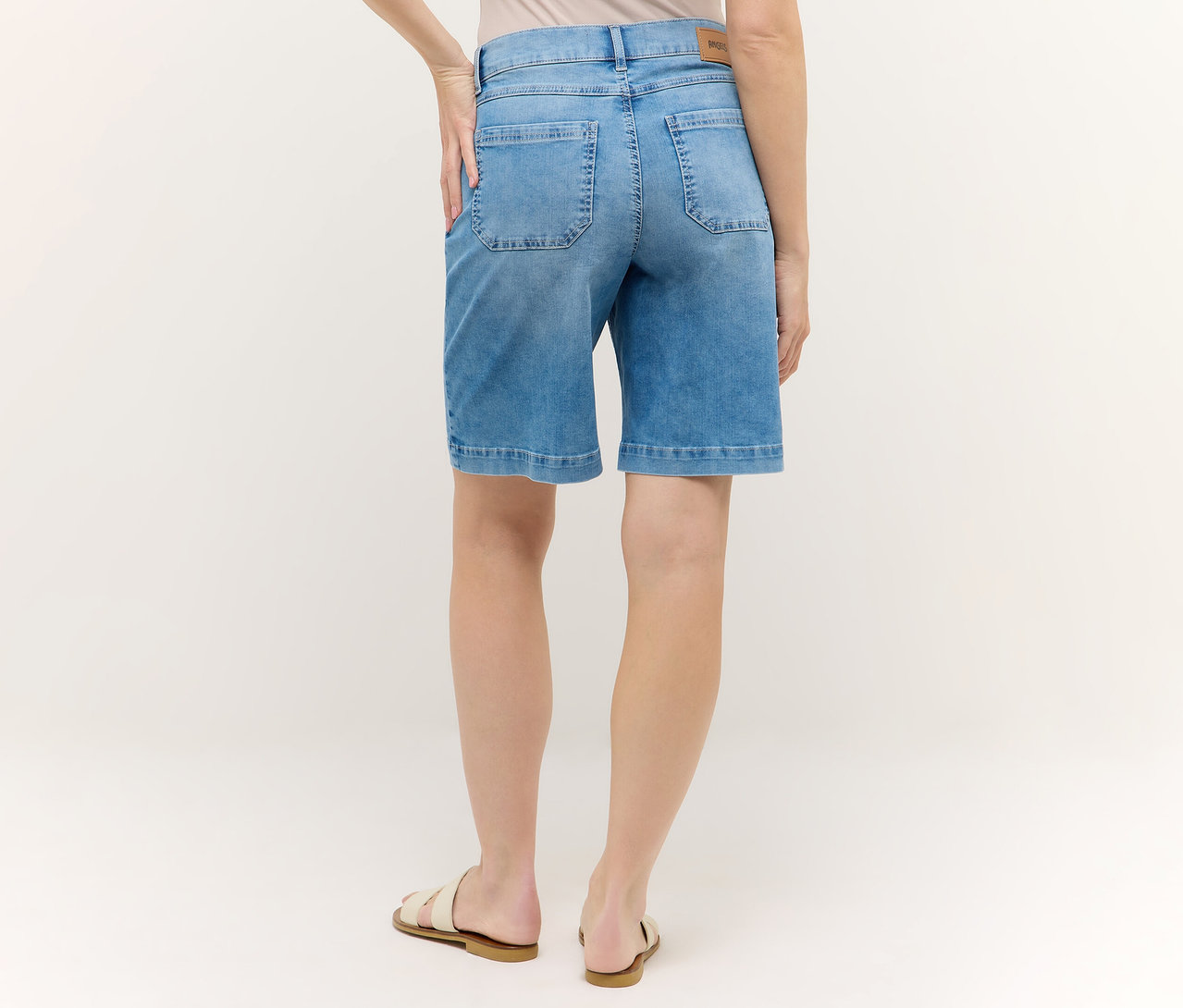 Rückansicht einer Frau in blauen Angels Denim »Lia Urban« Shorts und Sandalen.