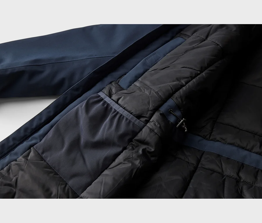 Dunkelblaue Jacke mit schwarzem, gestepptem Innenfutter und einer dunkelblauen Stoffbahn mit Kordelzug.