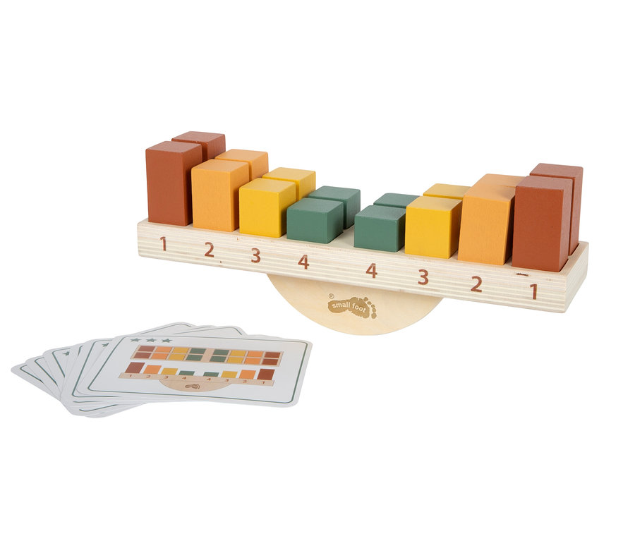 Holzwaage-Spielzeug mit bunten braunen, orangen, gelben und grünen Blöcken auf nummerierter Basis, daneben ein Stapel Musterkarten.