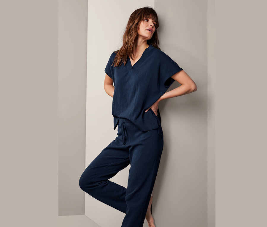 Frau posiert in Feinstrick-Loungewear-Sweatshirt und Hose.