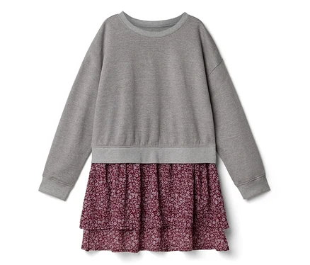 Ein Kleid mit einem grauen Langarm-Sweatshirt-Oberteil und einem gestuften, bordeauxroten Rock mit kleinem Blumenmuster.