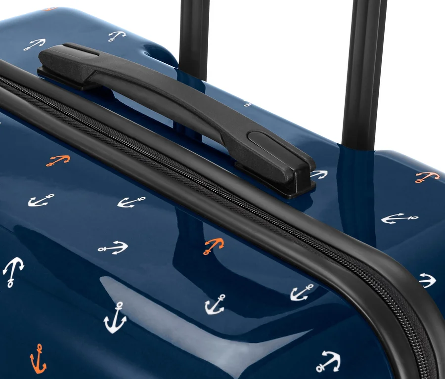 Detailansicht von einem kleinen Hartschalen-Koffer mit blauem Hintergrund und Anker-Muster.