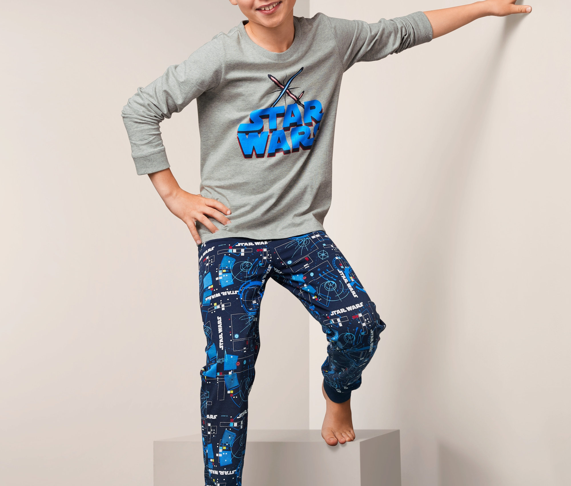 Junge posiert auf Stufen in »Star Wars«-Pyjama.