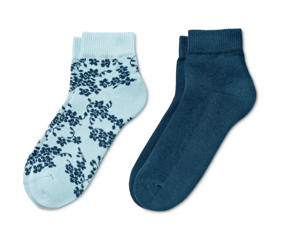 Zwei Paar Socken: hellblaue Socken mit dunkelblauem Blumenmuster und einfarbig dunkelblaue Socken. 2 Paar Hygge-Socken
