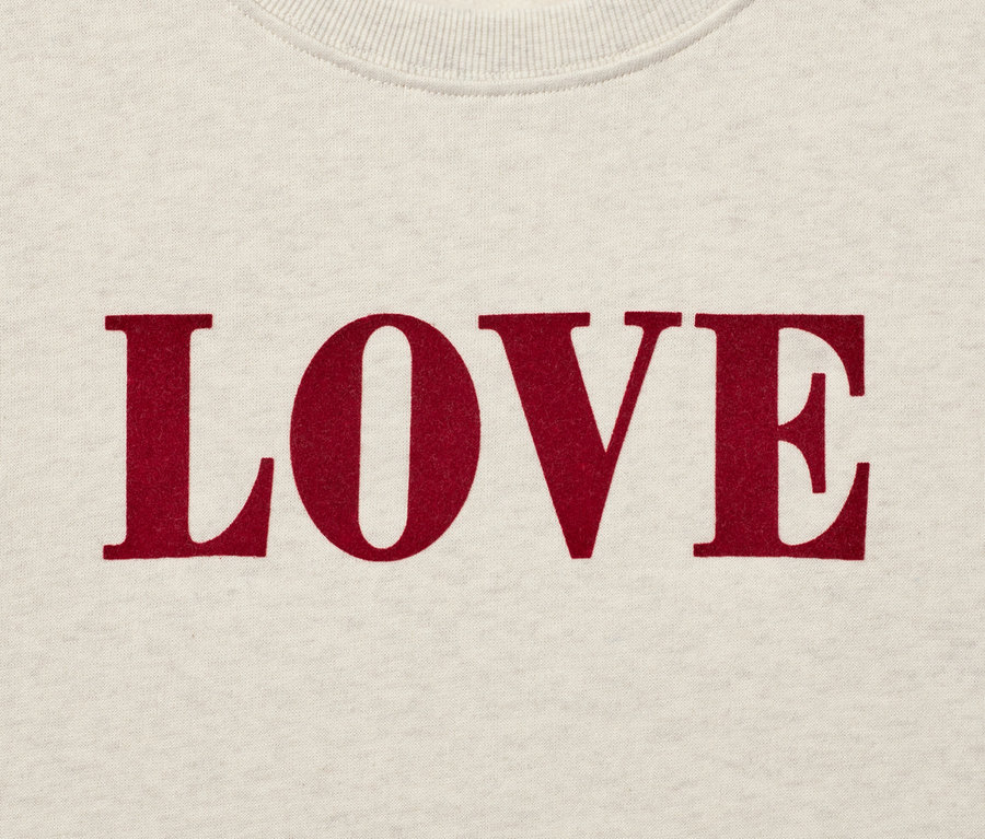 Detailansicht eines Sweatshirts in Creme mit dem roten Schriftzug LOVE.