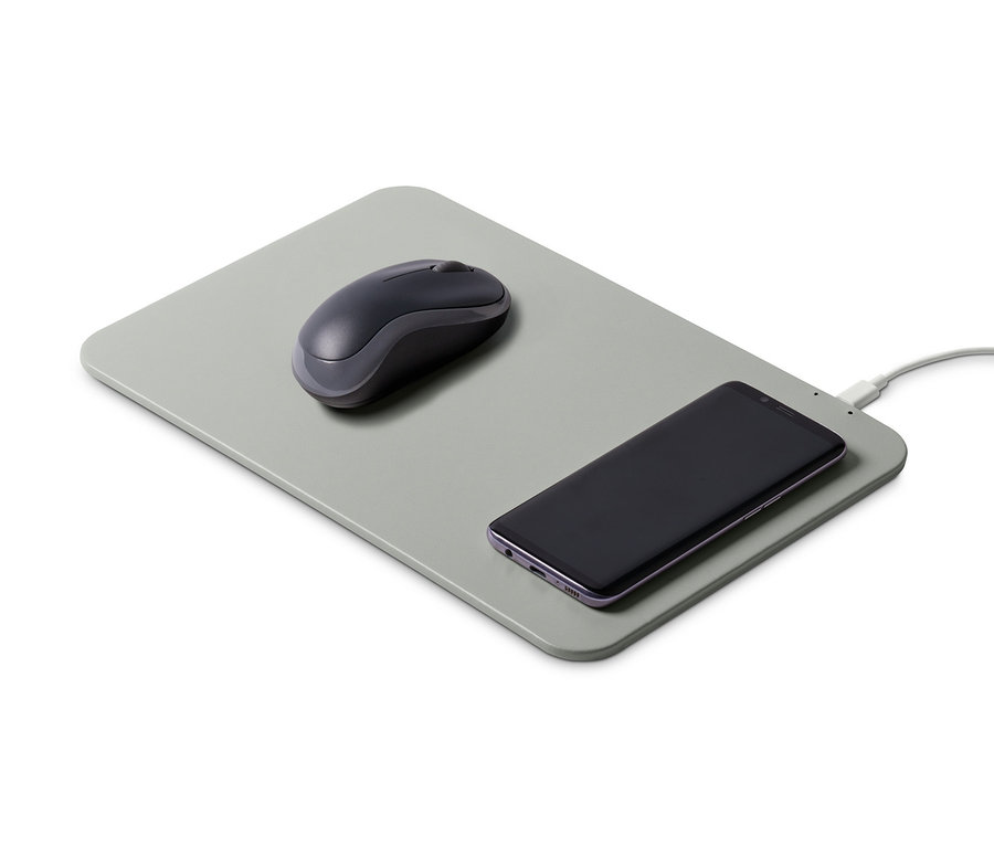 Graues Mauspad mit integriertem Ladegerät, auf dem eine Maus und ein aufladendes Telefon liegen.