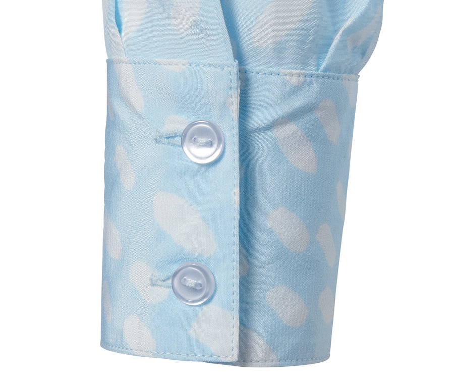 Detailaufnahme einer Bluse mit Print und zwei Knöpfen.