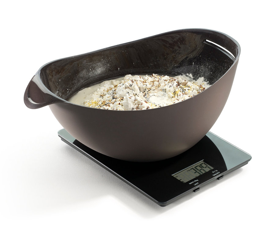 Eine braune Schüssel mit Inhalt steht auf einer schwarzen Digitalwaage. Lékué Brotback-Set.
