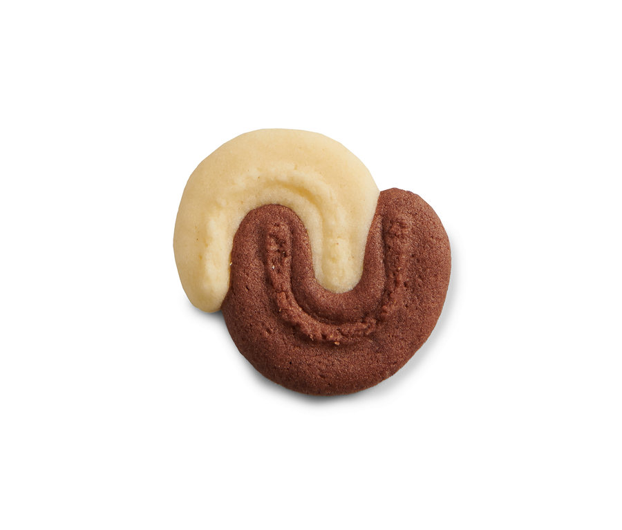 Nahaufnahme eines Kekses aus der Kekspresse, der halb hell und halb dunkel ist.
