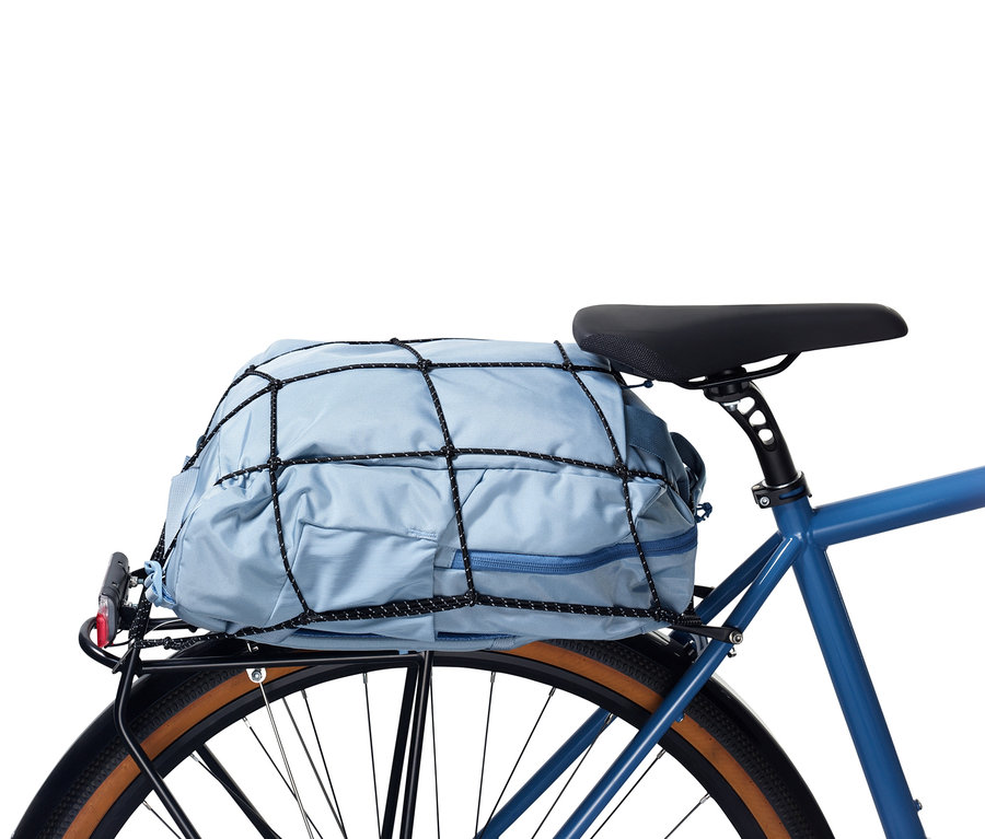 Eine blaue Tasche ist mit einem schwarzen Fahrrad-Gepäcknetz auf einem Fahrradträger befestigt.