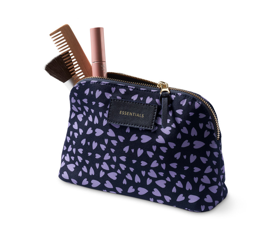 Eine Kosmetiktasche mit einem Kamm und einem Pinsel auf einem weißen Hintergrund.