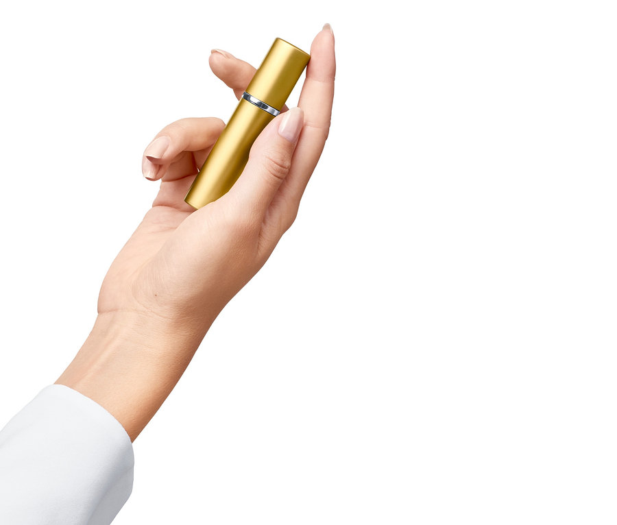 Hand hält goldenen Tascheninhalator.